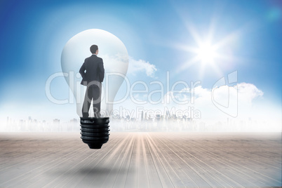 Composite image of thinking businessman in light bulb