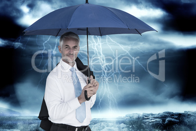 Composite image of businessman holding blue umbrella