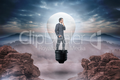 Composite image of thinking businessman in light bulb