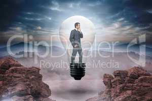 Composite image of thinking businessman in light bulb