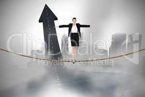 Composite image of businesswoman performing a balancing act