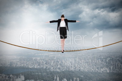 Composite image of businesswoman performing a balancing act