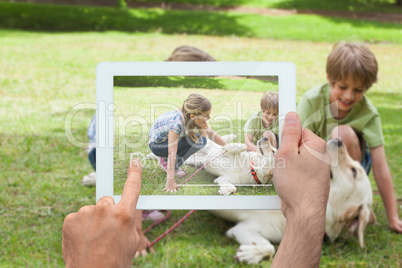 Composite image of hand holding tablet pc