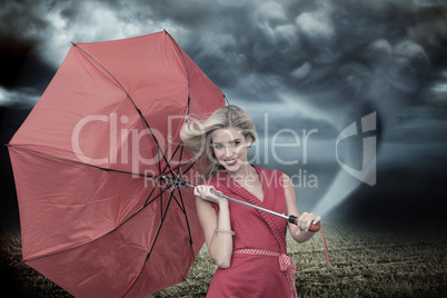 Composite image of smiling blonde holding umbrella