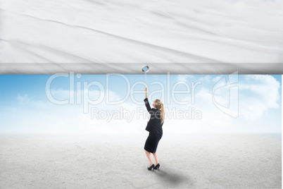 Composite image of businesswoman pulling a white screen