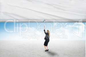 Composite image of businesswoman pulling a white screen