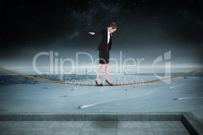 Composite image of businesswoman performing a balancing act