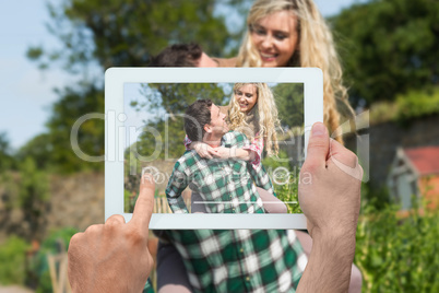 Composite image of hand holding tablet pc