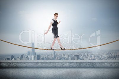 Composite image of businesswoman doing a balancing act