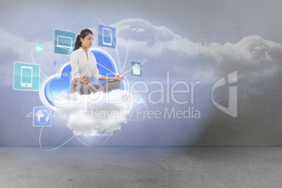 Composite image of businesswoman sitting in lotus pose