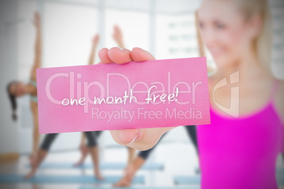 Fit blonde holding card saying one month free
