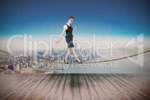 Composite image of businesswoman doing a balancing act