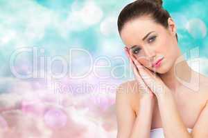 Composite image of beautiful brunette with hands at face