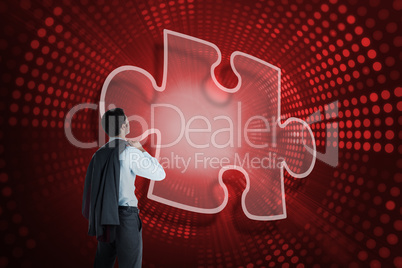 Composite image of jigsaw piece and businessman looking