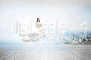 Composite image of businesswoman holding tablet and looking up