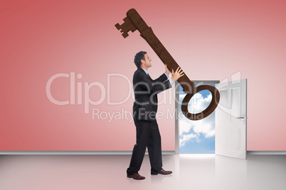 Composite image of stressed businessman carrying large key