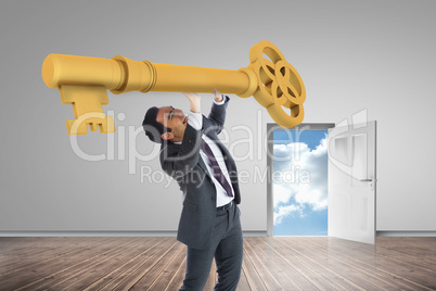 Composite image of stressed businessman carrying large key