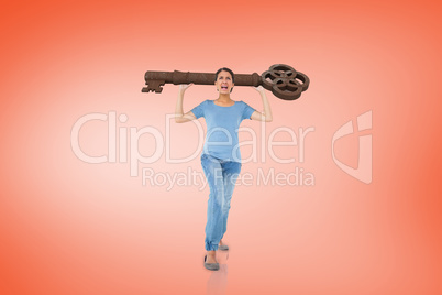 Composite image of annoyed brunette carrying large key