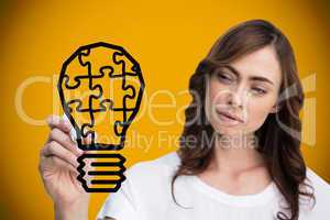 Composite image of businesswoman drawing light bulb