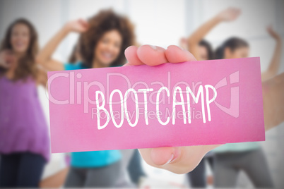 Woman holding pink card saying bootcamp