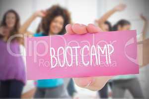 Woman holding pink card saying bootcamp