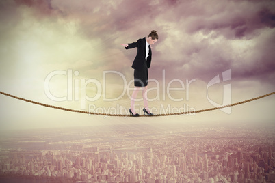 Composite image of businesswoman performing a balancing act