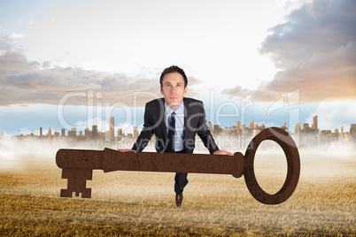 Composite image of businessman carrying large key