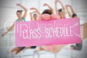 Woman holding pink card saying class schedule
