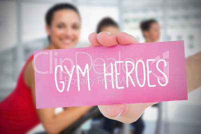 Woman holding pink card saying gym heroes