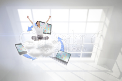 Composite image of cheering businesswoman sitting cross legged