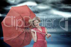 Composite image of smiling blonde holding umbrella