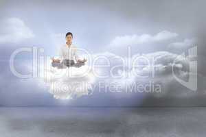 Composite image of businesswoman sitting in lotus pose