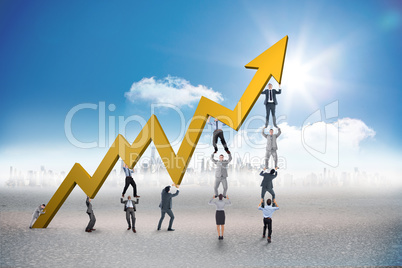 Composite image of business team holding up arrow