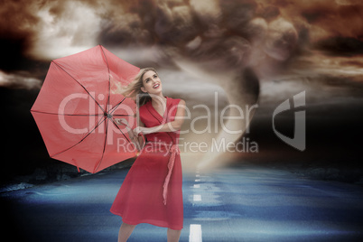 Composite image of elegant blonde holding umbrella