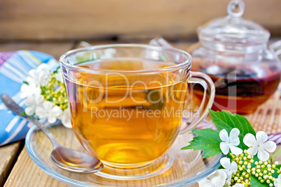 Tea from flowers of viburnum on wooden board with napkin