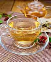 Tea with lingonberry in glass cup on bamboo napkin