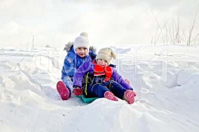 Two girls on sled in winter