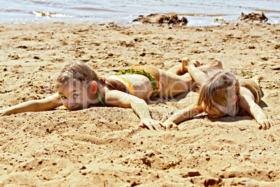 Two girls on sand by the river