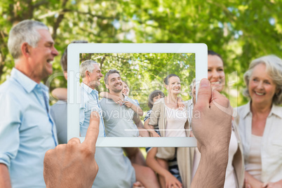 Composite image of hand holding tablet pc