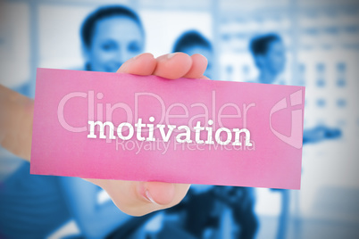 Woman holding pink card saying motivation