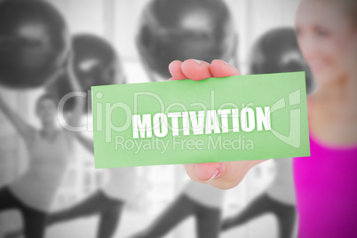 Fit blonde holding card saying motivation