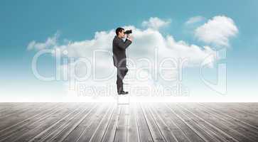 Composite image of businessman standing on ladder