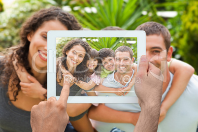 Composite image of hand holding tablet pc