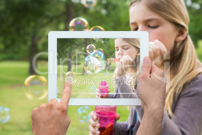 Composite image of hand holding tablet pc