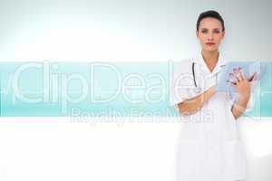 Composite image of pretty nurse using tablet pc