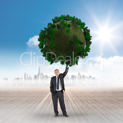 Composite image of businessman holding green sphere