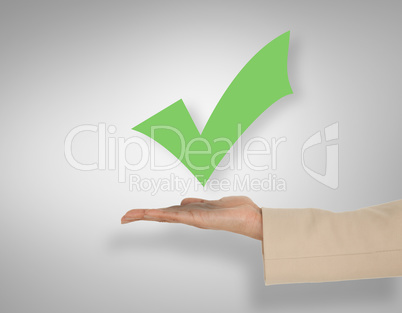 Composite image of female hand presenting green tick