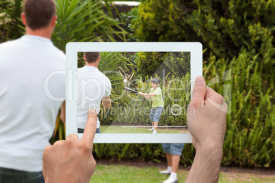 Composite image of hand holding tablet pc