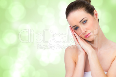 Composite image of beautiful brunette with hands at face