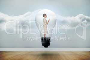 Composite image of thinking businesswoman in light bulb